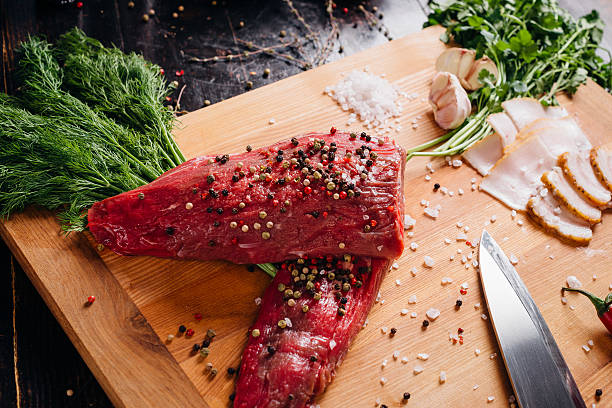 Raw meat on a cutting board with lard and spices. stock photo