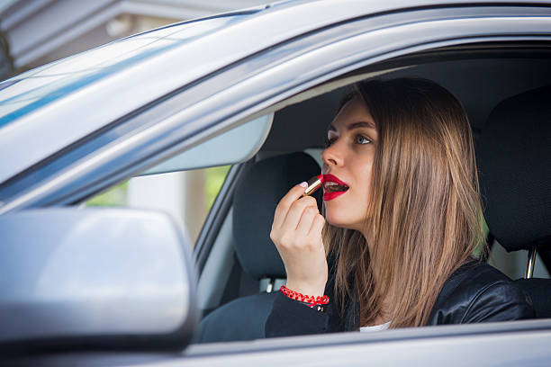istock Young woman applying makeup while in the car 545446598