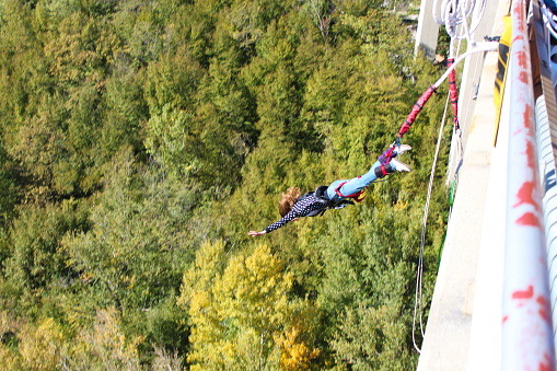 Girl bungee jumping above the river.