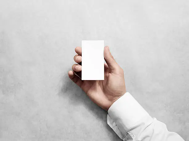 Photo of Hand hold blank vertical white business card design mockup.