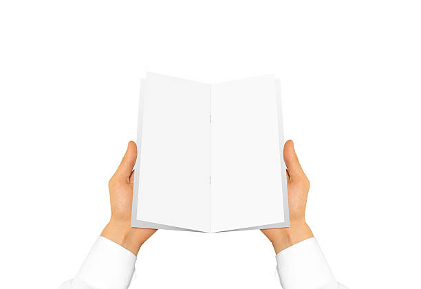 istock Hand in white shirt sleeve holding blank brochure booklet in 545448222