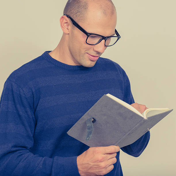 istock Studio portrait of balding young man reading 545450858