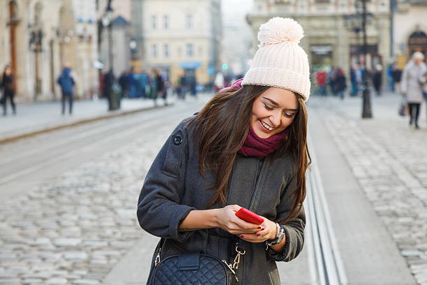 istock Laughing young woman holding red smart phone 545453034