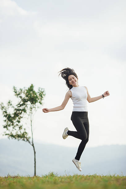 istock Asian girl jumping on the meadow. 545455034
