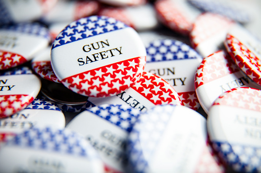 Close up of Vote election buttons, with red, white, blue and stars and stripes. Gun Safety/Gun Control are important issues facing the United States this election season.