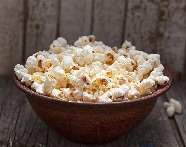 istock Fresh popcorn in bowl on white wooden table 545456720