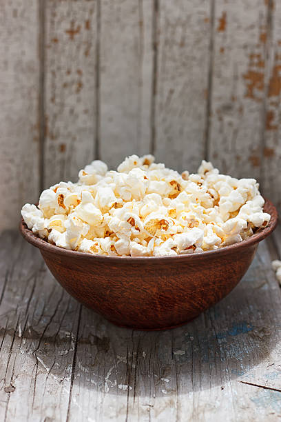 istock Fresh popcorn in bowl on white wooden table 545456914