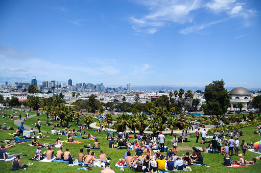 Crowds of people enjoying the summer weather at Dolores Park, located in the Mission District in San Francisco, California.