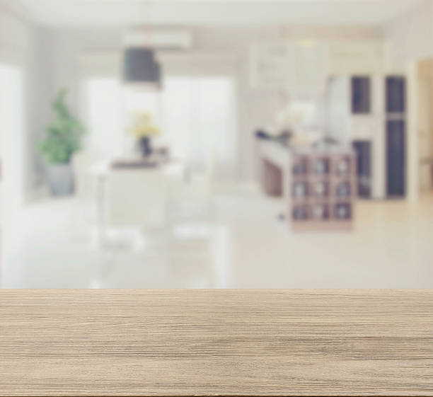 istock wooden table top with blur of modern dining room interior 545457348
