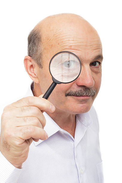 istock elderly man looks at something through a magnifying glass. 545461328