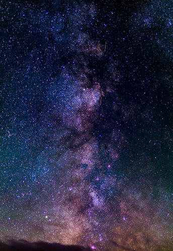 The outstanding beauty and clarity of the Milky Way, with details of its colorful core. Vertical panorama of 6 stitched photos. Telephoto captured high up from the Alps.