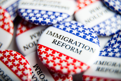 Close up of Vote election buttons, with red, white, blue and stars and stripes. Immigration Reform is an important issue facing the United States this election season.