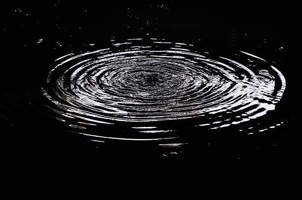 water ripples from a drop of water in the dark. - ripple nature water close to imagens e fotografias de stock