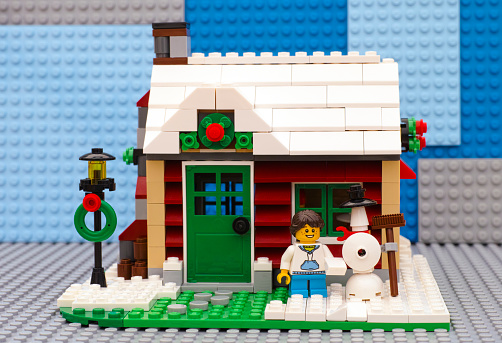 Tambov, Russian Federation - July 06, 2016 Lego Winter House. Girl building snowman in front of house. Studio shot.