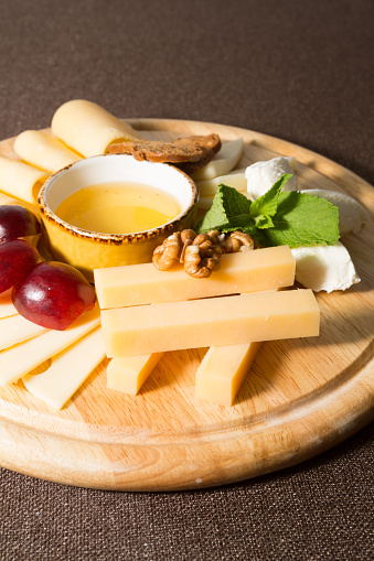 Different sorts of cheese served on wooden board
