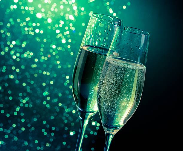 istock champagne flutes with golden bubbles on dark green bokeh background 545467068