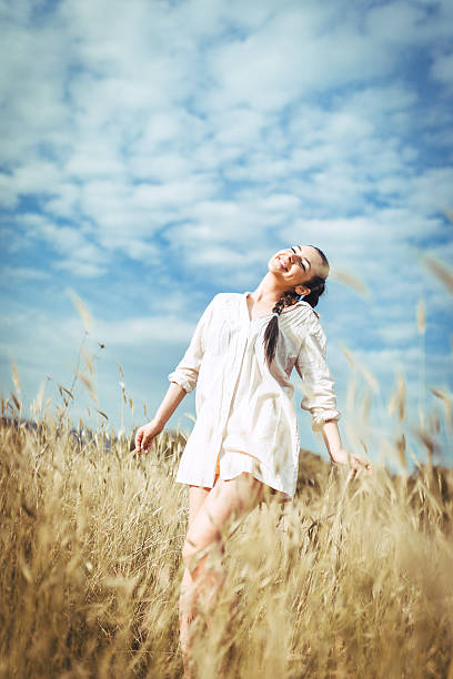 istock Pretty young woman in field at sunset 545467438