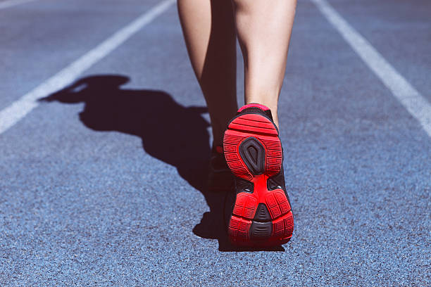 istock Athlete runner feet down stadium track. Closeup 545547702