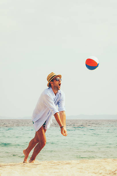 istock Young man playing on the beach with a ball 545547882