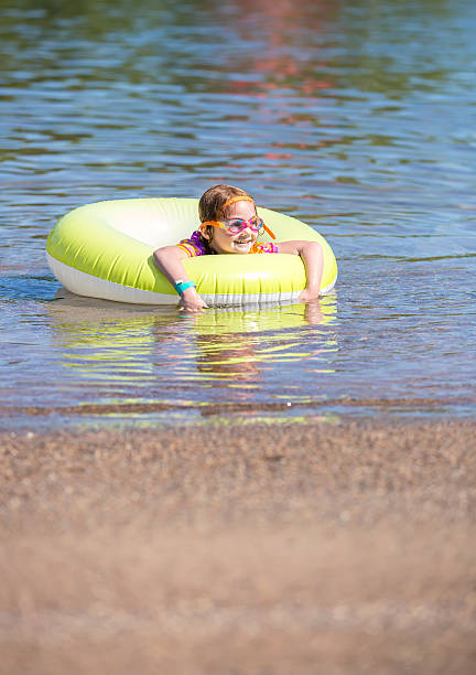 istock Girl Playing In Inner Tube Float at Beach 545548620