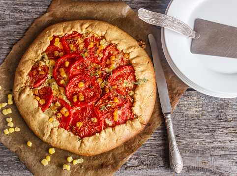 Homemade summer outdoor pie with tomatoes, corn and thyme. Galette