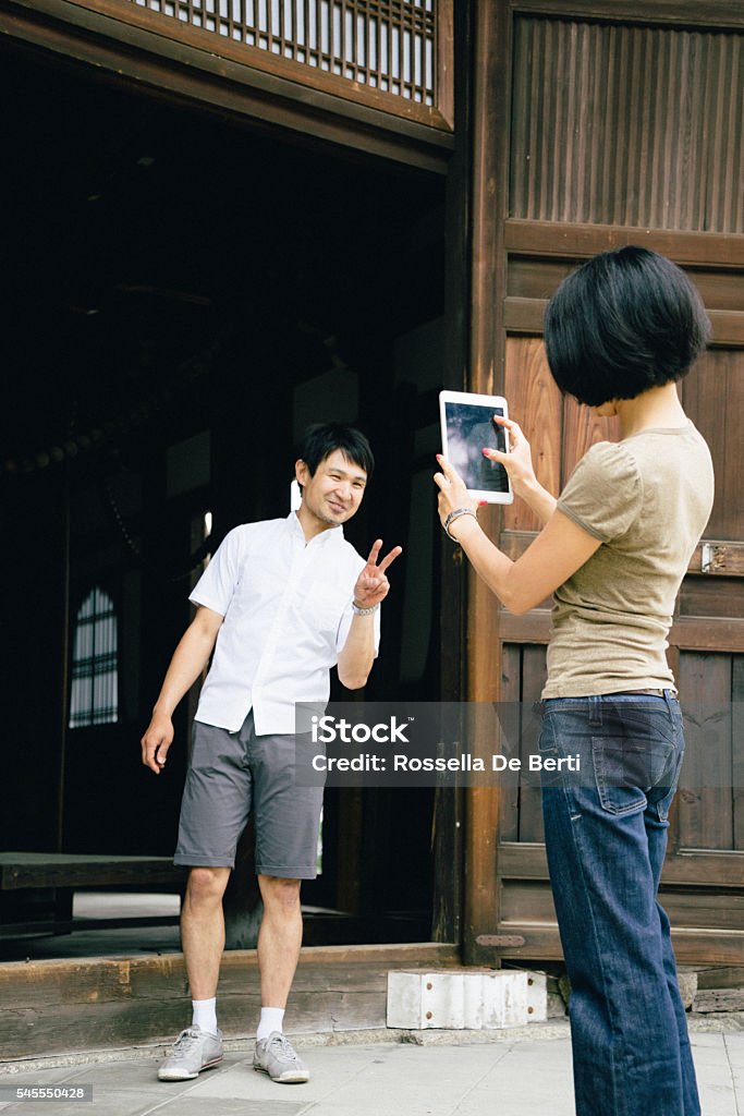 Japanese couple visiting a buddhist temple taking a memory picture Japanese couple visiting a buddhist temple in Japan and taking a memory picture. 30-39 Years Stock Photo