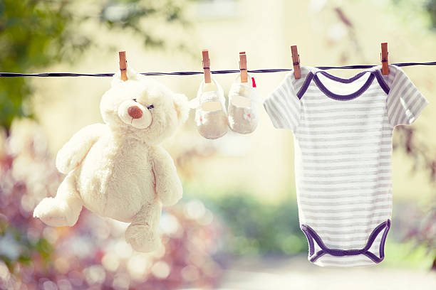 istock Baby clothes, boots and teddy hanging on the clothesline 545550742