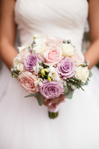 wedding bouquet of roses in hands of the bride