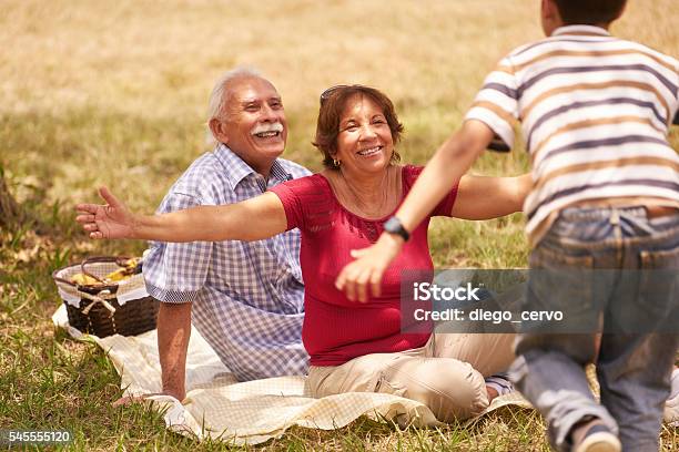 Grandparents Senior Couple Hugging Young Boy At Picnic Stock Photo - Download Image Now