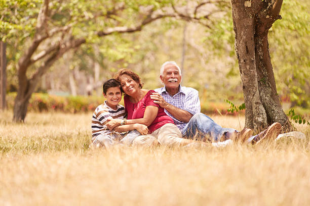 istock Grandparents Senior Couple Hugging Young Boy On Grass 545555156