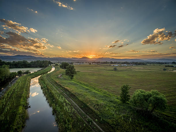 sunset over Rocky Mountains and foothills sunset over Rocky Mountains and foothills with an irrigation ditch - aerial view, northern Colorado near Loveland foothills photos stock pictures, royalty-free photos & images