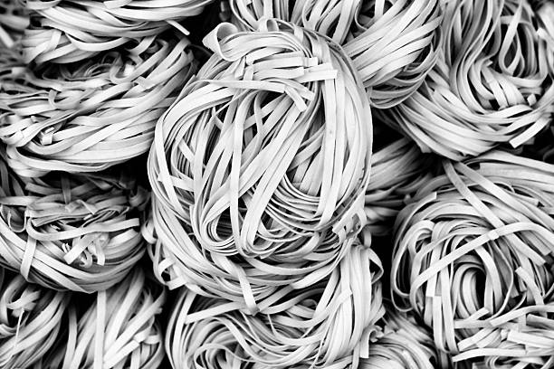 Fresh Dried noodles on drying rack. Outdoor Chinese Traditional Local Homemade Noodle Factory. Yellow pasta Or egg noodles background texture pattern. Instant  Mee Sua Chinese noodles Handmade.