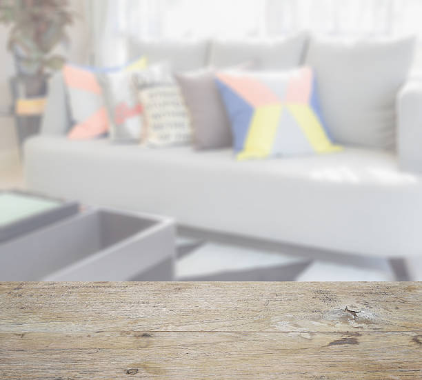 istock wooden table top with blur of colorful pillows on sofa 545558408