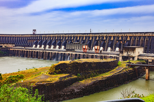 A section of the massive Itaipu Dam located between the South American countries of Brazil and Paraguay. It supplies hydro-electric power to both countries. Some of the huge penstock pipes can be seen in the image. Photo shot in the morning sunlight; horizontal format. No people. Copy space.