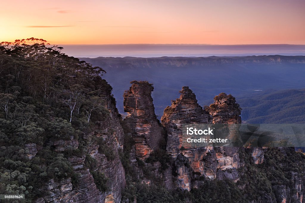 BM 3 Sisters Close Pink sunrise 3 Sisters landmark rock formation in Blue Mountains national park of Australia at sunrise as seen from Echo point, Katoomba, towards the Grand Canyon. Australia Stock Photo