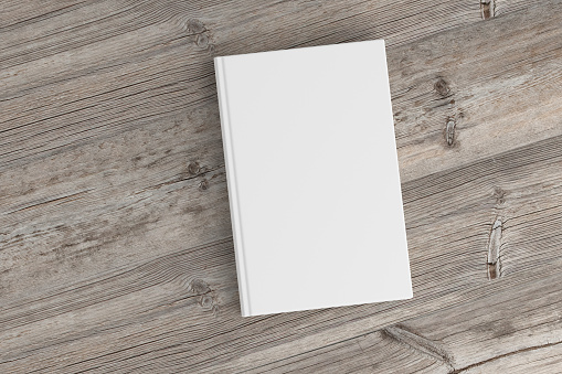 Blank book cover on wood background. Isolated with clipping path. 3d render