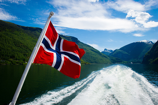 Norwegian Flag flowing in the wind on a fjord tour