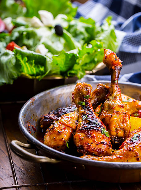 istock Grilled chicken legs, lettuce and cherry tomatoes limet olives. 545564578