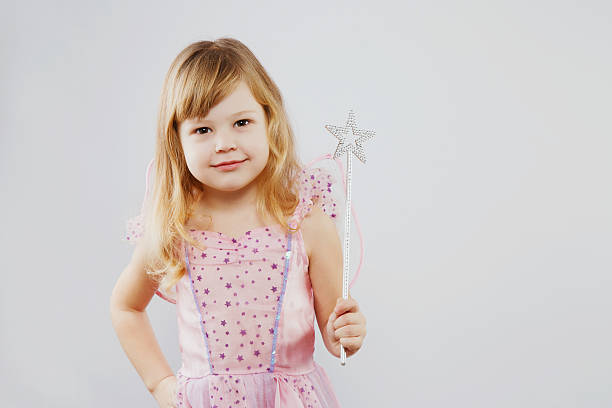istock Lovely little girl posing with magic stick in studio 545570442