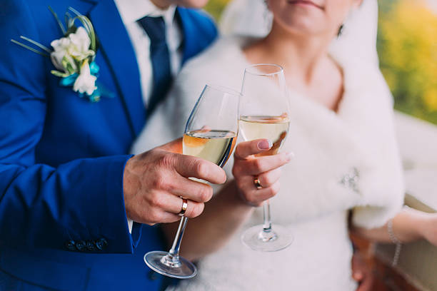 istock Newlyweds celebrating their wedding drinking champagne standing near the brick 545570836