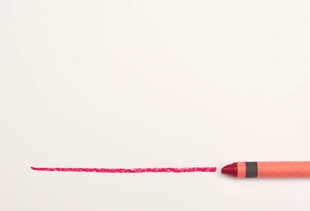 istock Red crayon drawing a line on white paper 545571062