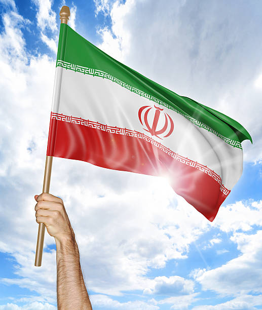 istock Person's hand holding the Iranian national flag and waving it 545571470