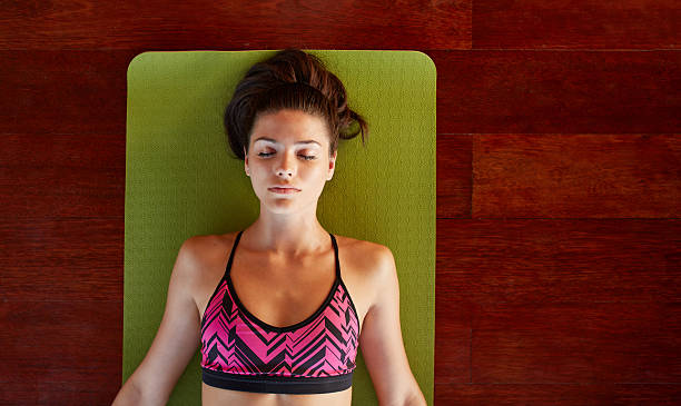 mulher saudável em savasana posa na academia - relaxation lying on back women meditating - fotografias e filmes do acervo