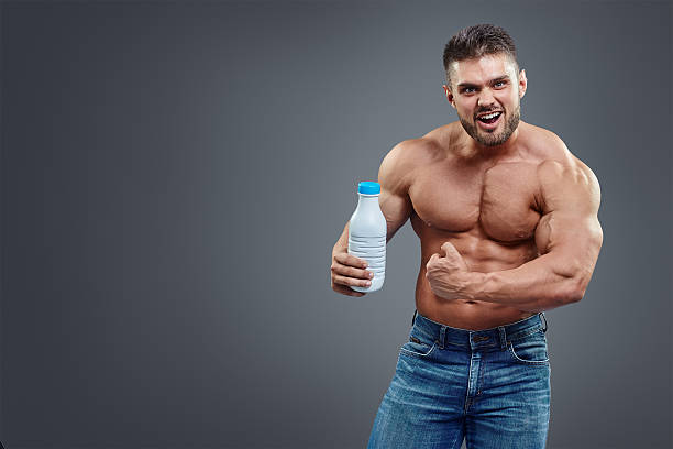 athletic young handsome man with white shake bottle. - creatine nutritional supplement men human muscle imagens e fotografias de stock