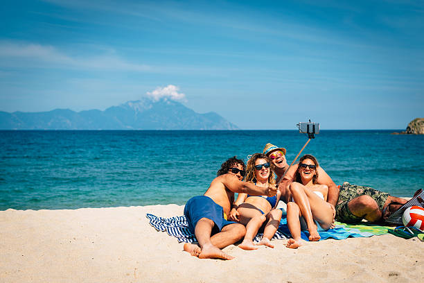 istock Image of cheerful friends taking selfie at beach 545578830