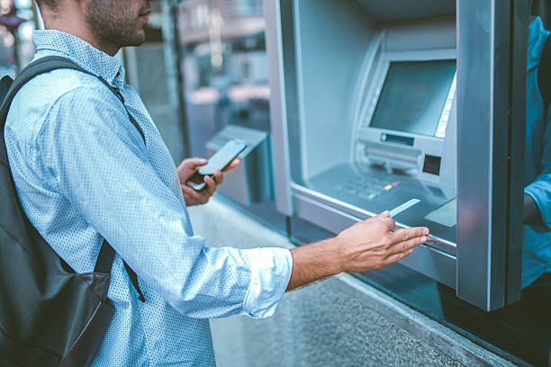 istock Young man withdrawing money from credit card at ATM. 545580512