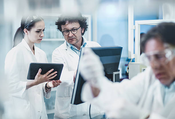 scienziati che lavorano presso il laboratorio - teamwork medical research science women foto e immagini stock