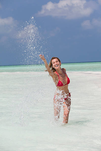 istock woman splashing in a transparent sea 545582044