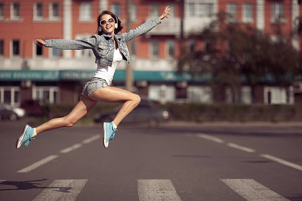 portrait of the beautiful young woman jumping in the park