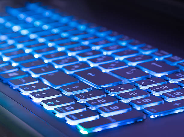 istock pc keyboard with blue light tint, close-up view 545589134